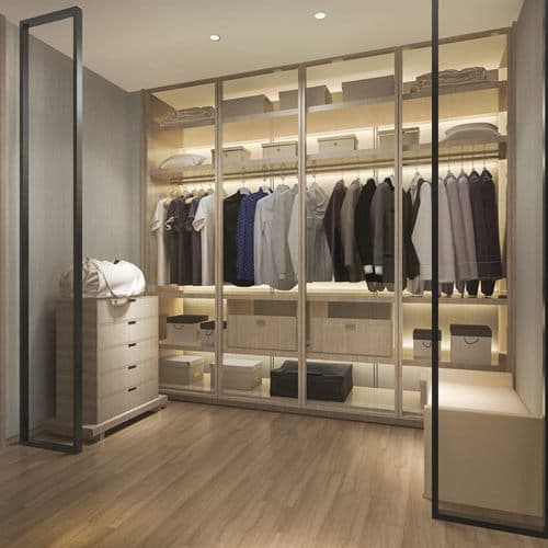 Vestidor a medida con puertas de cristal e iluminación interior en Noia